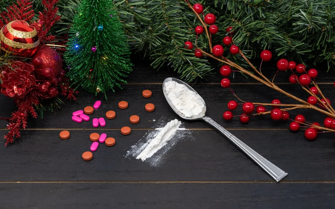 Various pills and powdered substances on a dark wooden surface with festive holiday decorations.