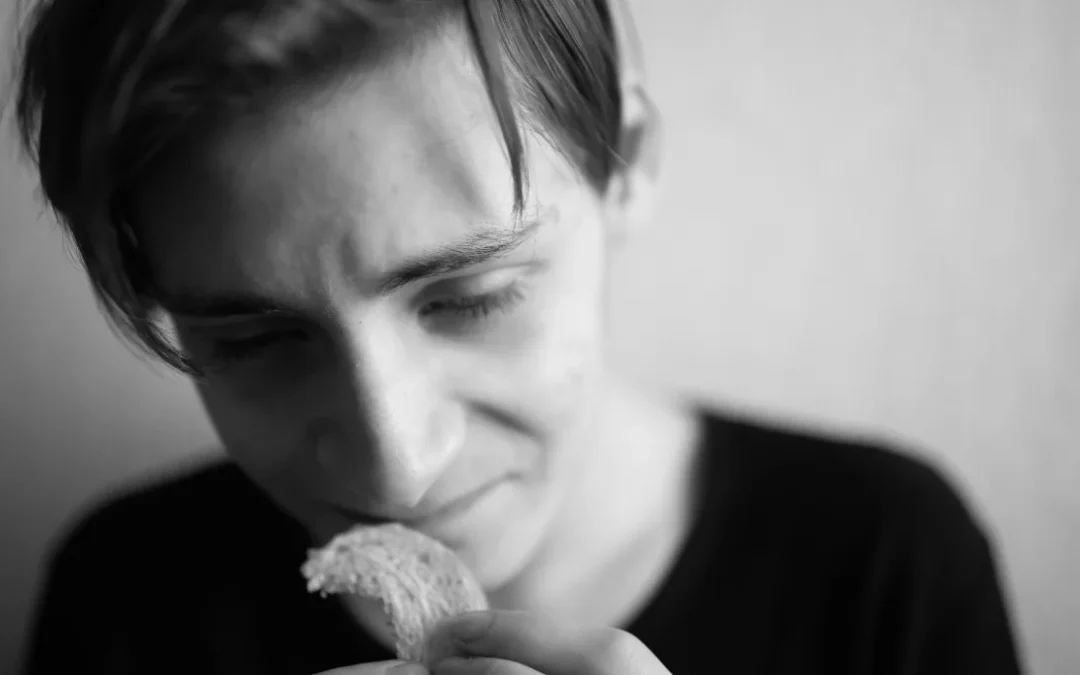thin and emaciated young man eating bread